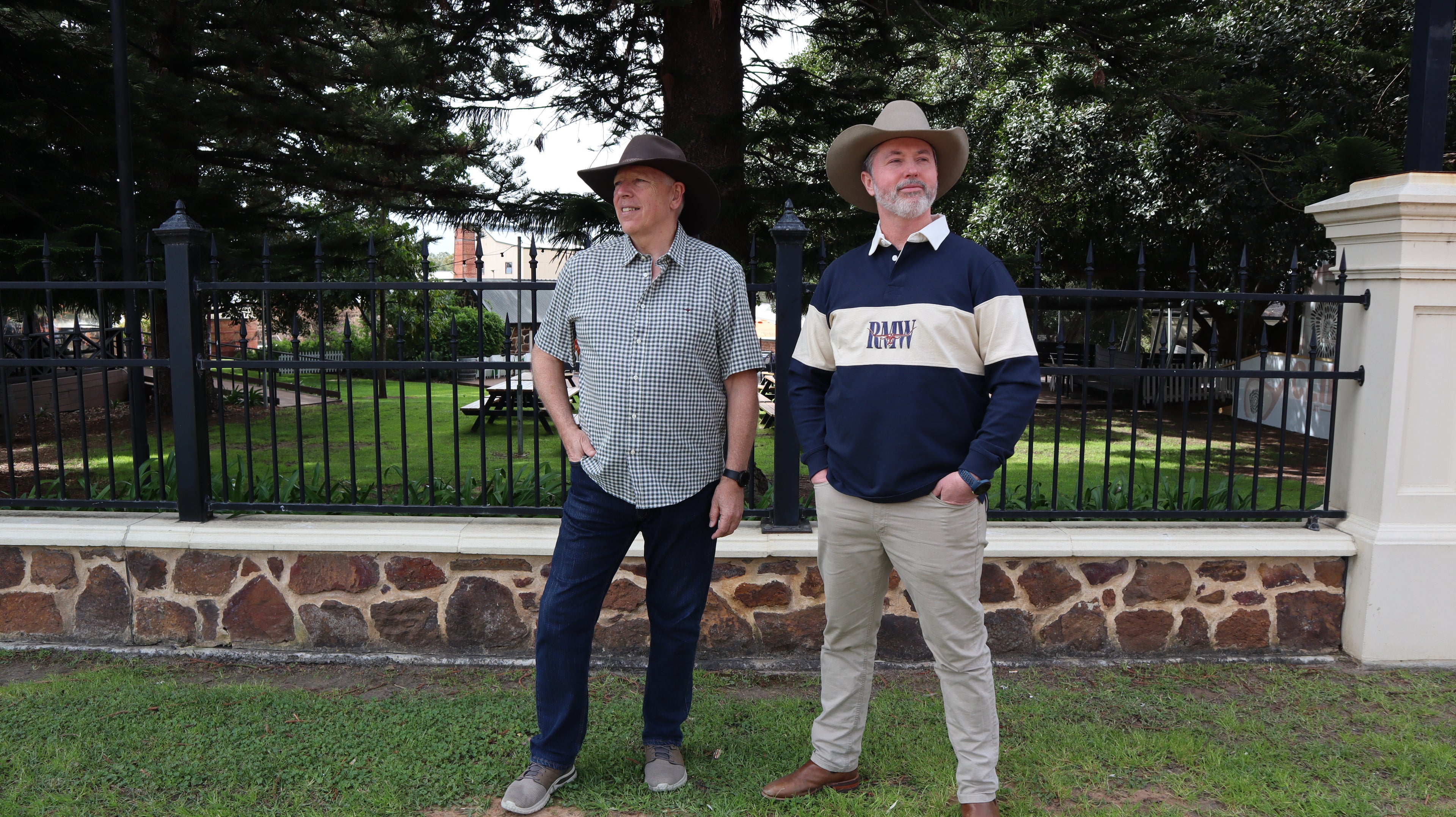 Two men standing outside wearing RM Williams Clothing and Akubra hats in McLaren Vale. 