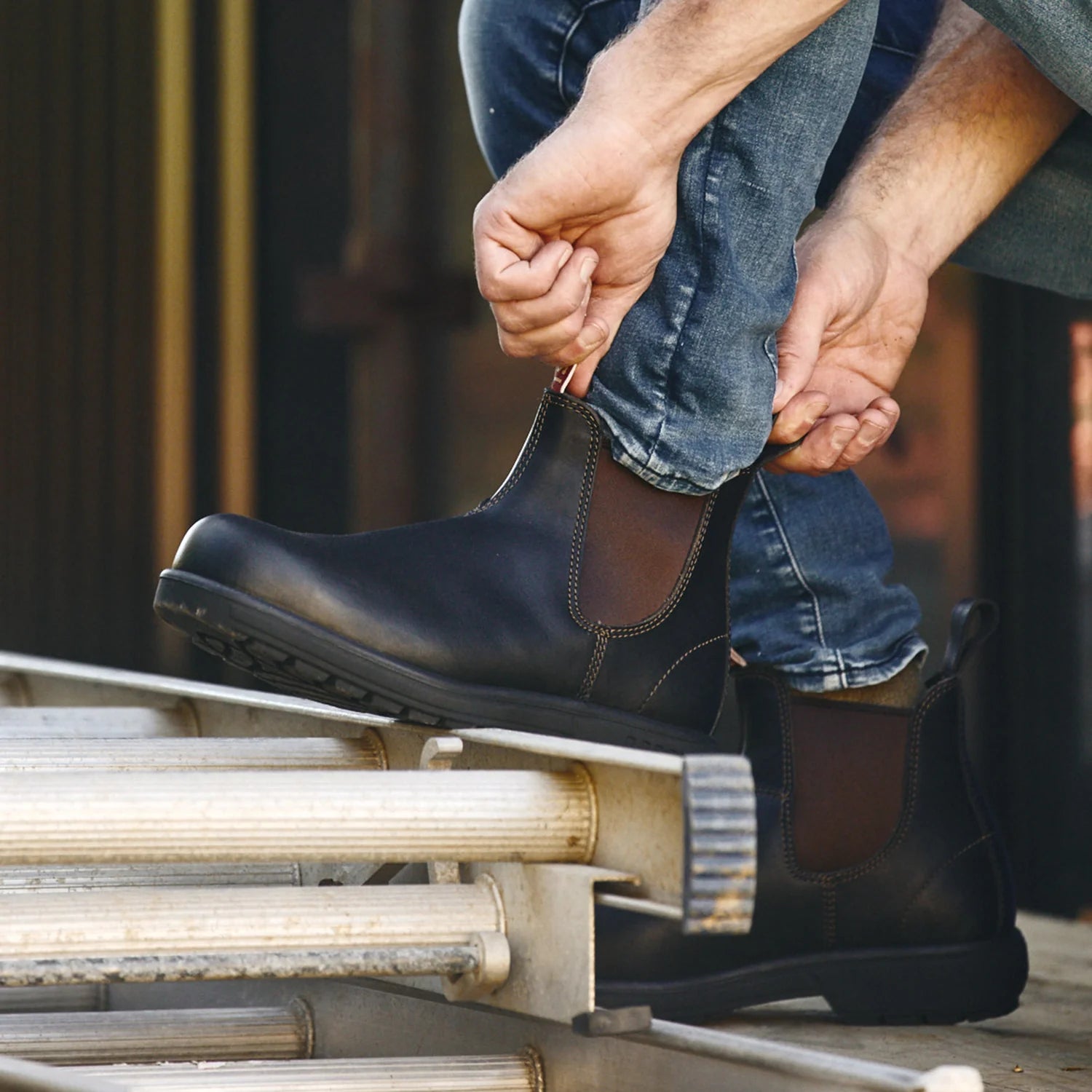 Image of a man pulling on the Rossi Trojan 700 Safety Work Boots in Claret. Available in McLaren Vale, 30 minutes south of Adelaide.